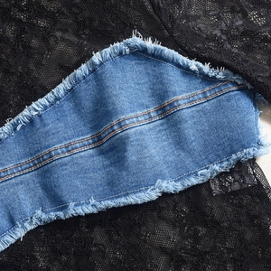 Détail du tissu en dentelle noire cousu avec du denim bleu et des bords effilochés