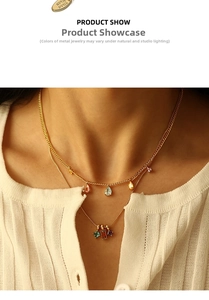 Detail of layered gold brass necklace with colorful zircon pendants on white cardigan
