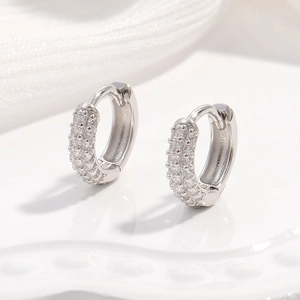 Vue macro des boucles d'oreilles créoles S925 en argent avec pétales en zircon
