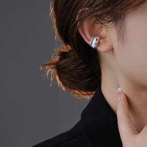Close-up detail of silver zircon ear cuff featuring a stylish twisted rope and stone design