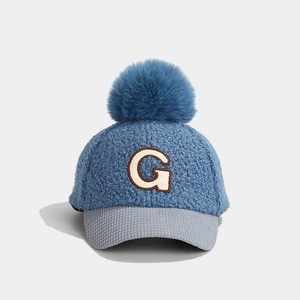 Detailansicht der blauen Lammwoll-Baseballkappe für Kinder mit Bommel und G-Patch