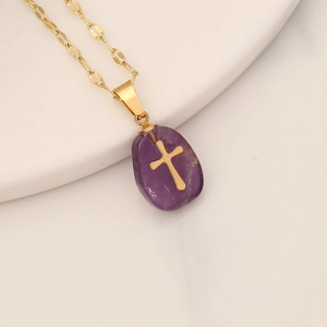 Minimalist gold necklace featuring a purple natural stone pendant with cross emblem