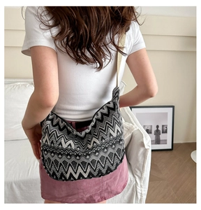 Détail d'un grand sac bandoulière en tricot avec motifs de vagues noir et blanc sur modèle