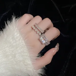 Bague multicouche élégante en argent avec zircon carré et perles portée à la main
