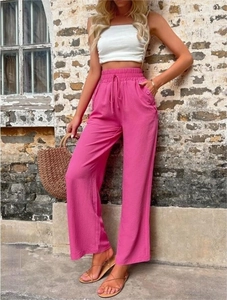 Détail du pantalon large rose à taille haute avec cordon et boutons sur le côté