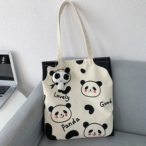 Detail einer Panda-Stofftasche mit schwarzen Nähten und einem süßen Panda-Plüschanhänger