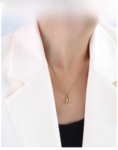 Chic 18k gold tiny lock pendant necklace worn by model in a minimalist professional style