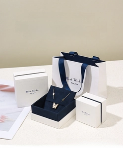 Detail of elegant cream jewelry box with drawer design and matching gift paper bag