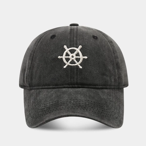 Close-up of vintage washed charcoal baseball cap with white nautical helm embroidery