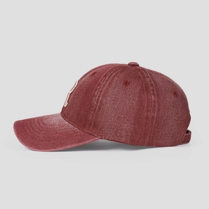 Détail de la casquette de baseball en denim bordeaux avec broderie de lettres blanches