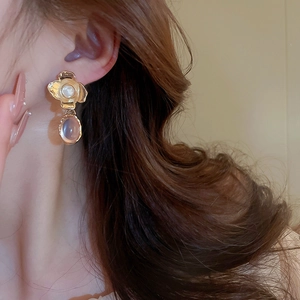 Close-up of vintage flower pearl earrings with pink translucent pendants on model