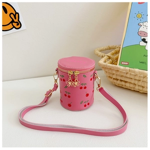 Detail of pink cylindrical bucket bag with red cherry prints and golden zipper