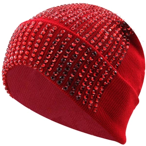 Dettaglio del berretto in maglia acrilica rossa con file verticali di strass brillanti
