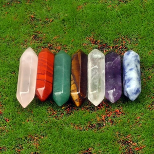 Lot de 7 colonnes de cristal hexagonales à double pointe sur un fond de gazon vert