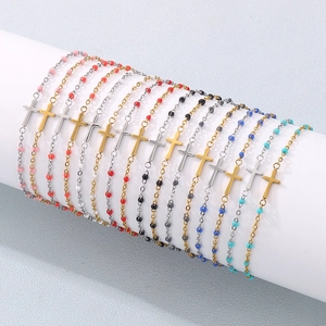 Close-up of colorful beaded cross bracelets in various colors on a white display stand