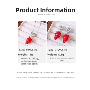 Detail view of strawberry pendant necklace and earrings set with pearl and rhinestone details