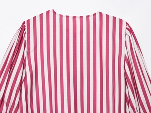 Detail of pink and white vertical stripes on a woven blouse with shoulder pleat details