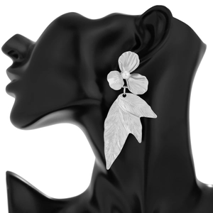 Macro detail of silver ginkgo leaf earring with pearl accent on a black mannequin