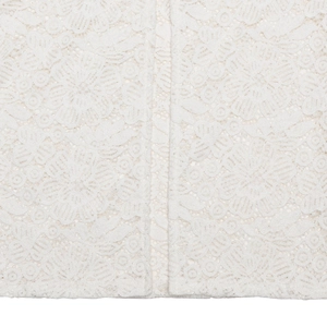 Dettaglio ravvicinato del tessuto in pizzo bianco con eleganti motivi floreali