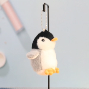 Detailed view of plush penguin keychain with soft fur and silver ball chain hanger
