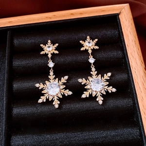 Close-up of 18k gold plated snowflake earrings with sparkling zircon in a jewelry box