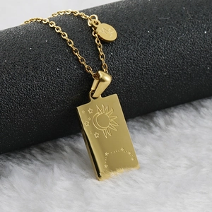Detail of 18K gold square Capricorn zodiac pendant necklace on textured background