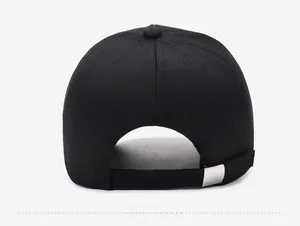 Detail view of adjustable strap with silver metal buckle on black cotton baseball cap