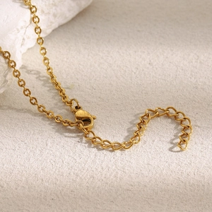 Macro detail of 18K gold-plated necklace chain with lobster clasp and extender