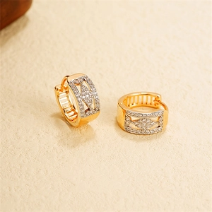 Detailed close-up of gold heart-shaped U-hoop earrings with sparkling pave rhinestones