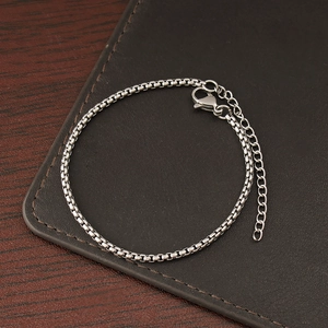 Close-up of a silver stainless steel box chain bracelet with lobster clasp and extender