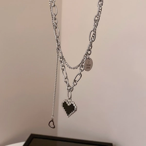 Détail de la chaîne argentée avec cœur pixel et pendentif rond gravé I Love You