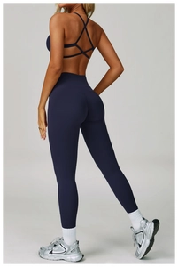 Detail of cross-back yoga bra and high-waisted leggings in navy blue matte fabric