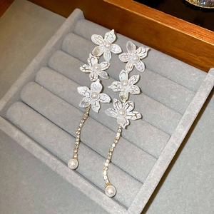Elegant lily earrings with iridescent petals, pearls and sparkling tassel chains