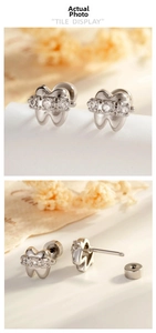 Detailed view of silver tooth-shaped cartilage studs with three sparkling zircons
