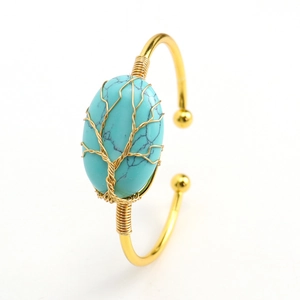 Close-up of handmade wire-wrapped tree of life design on oval turquoise bangle