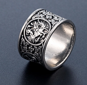 Macro detail of retro punk silver ring featuring intricate dragon relief and scrollwork