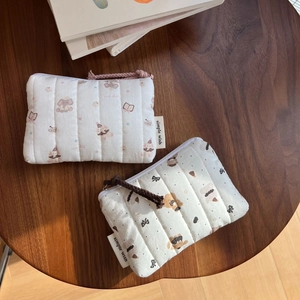 Detailed macro view of quilted cotton pouches with cute teddy bear and elephant patterns