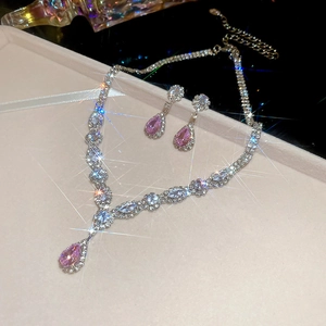 Sparkling pink teardrop zircon necklace and earrings set on a beige velvet jewelry tray