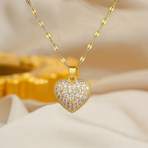 Elegant gold-tone heart necklace with sparkling crystals on a soft satin background