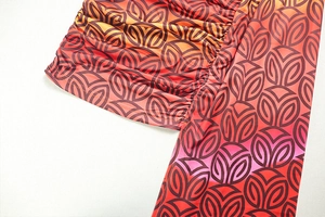 Macro view of geometric gradient print detail with ruched texture on a mini dress