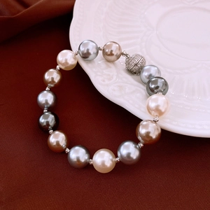 Détail de colliers en perles multicolores avec fermoirs magnétiques sur porcelaine vintage