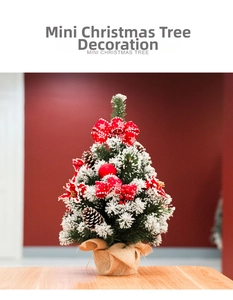 Detailed view of mini snow-flocked Christmas tree with red bows and burlap base