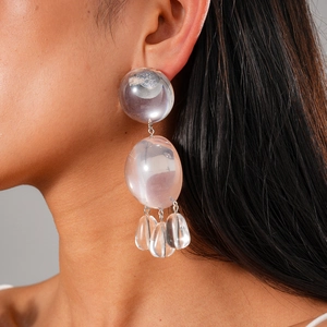 Boucles d'oreilles en résine transparente portées montrant texture et style unique
