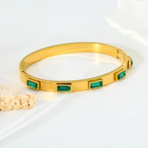 Detailed macro of gold plated stainless steel bangle with five green zircon stones