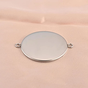 Polished silver stainless steel round pendant base tray with dual connectors on pink fabric