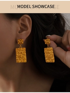 Gros plan sur des boucles d'oreilles vintage dorées à texture martelée et design carré