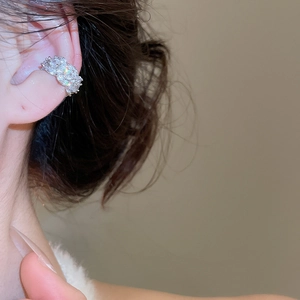 Close-up of elegant silver ear cuff with sparkling cubic zirconia on a female model's ear