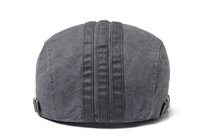 Detail view of dark grey cotton flat cap with vertical stripes and side metal buckles