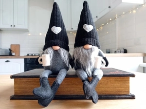 Gnomes de Noël faits main avec bonnets tricotés posés sur des livres dans une cuisine