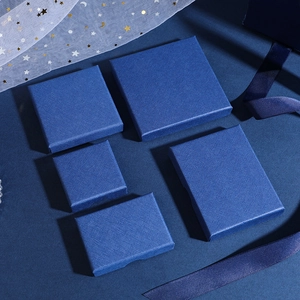 Detail of dark blue jewelry gift boxes with textured surfaces and elegant white tulle